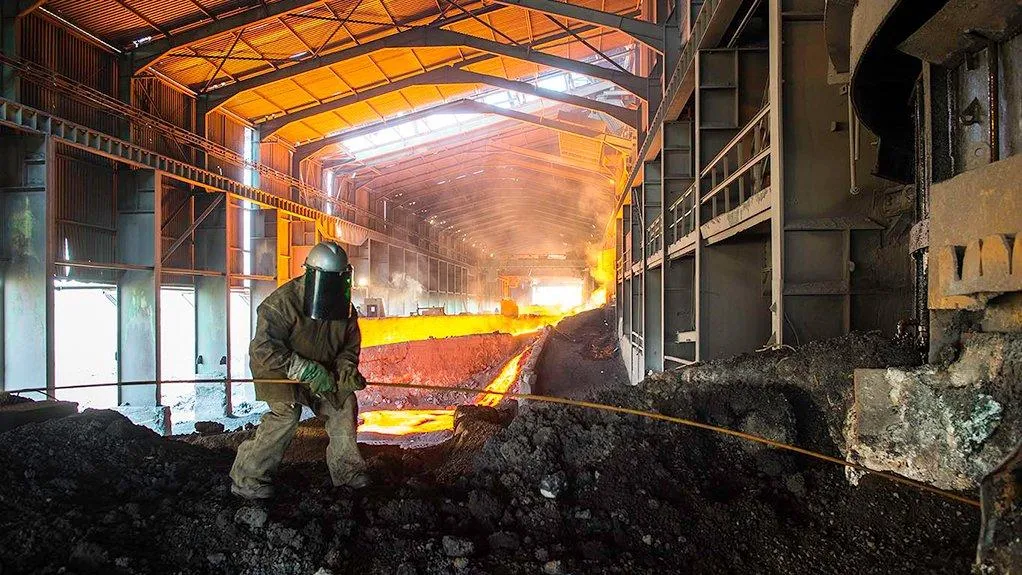 Furnace worker tapping molten metal in a smelter